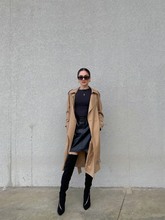 a lady in a oversized double-breasted trench coat with mini leather skirt